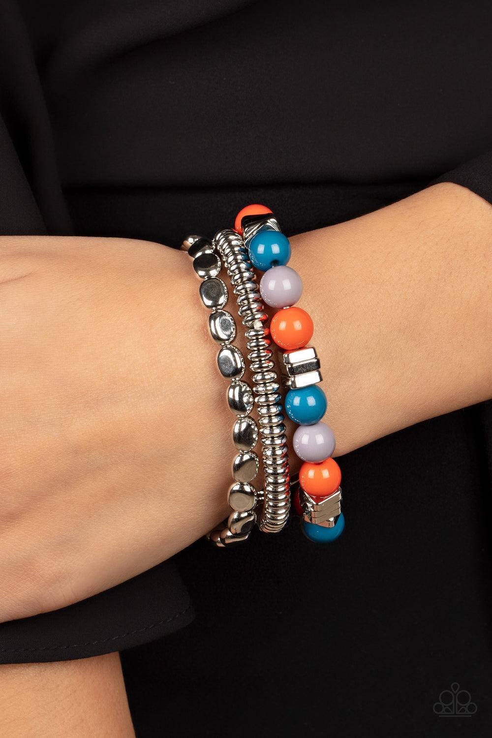 Paparazzi Accessories Tour de Tourist - Multi A mismatched collection of silver discs, silver cubes, bubbly multicolored acrylic, and silver pebble-like beads are threaded along stretchy bands around the wrist, creating fiery layers. Sold as one set of th
