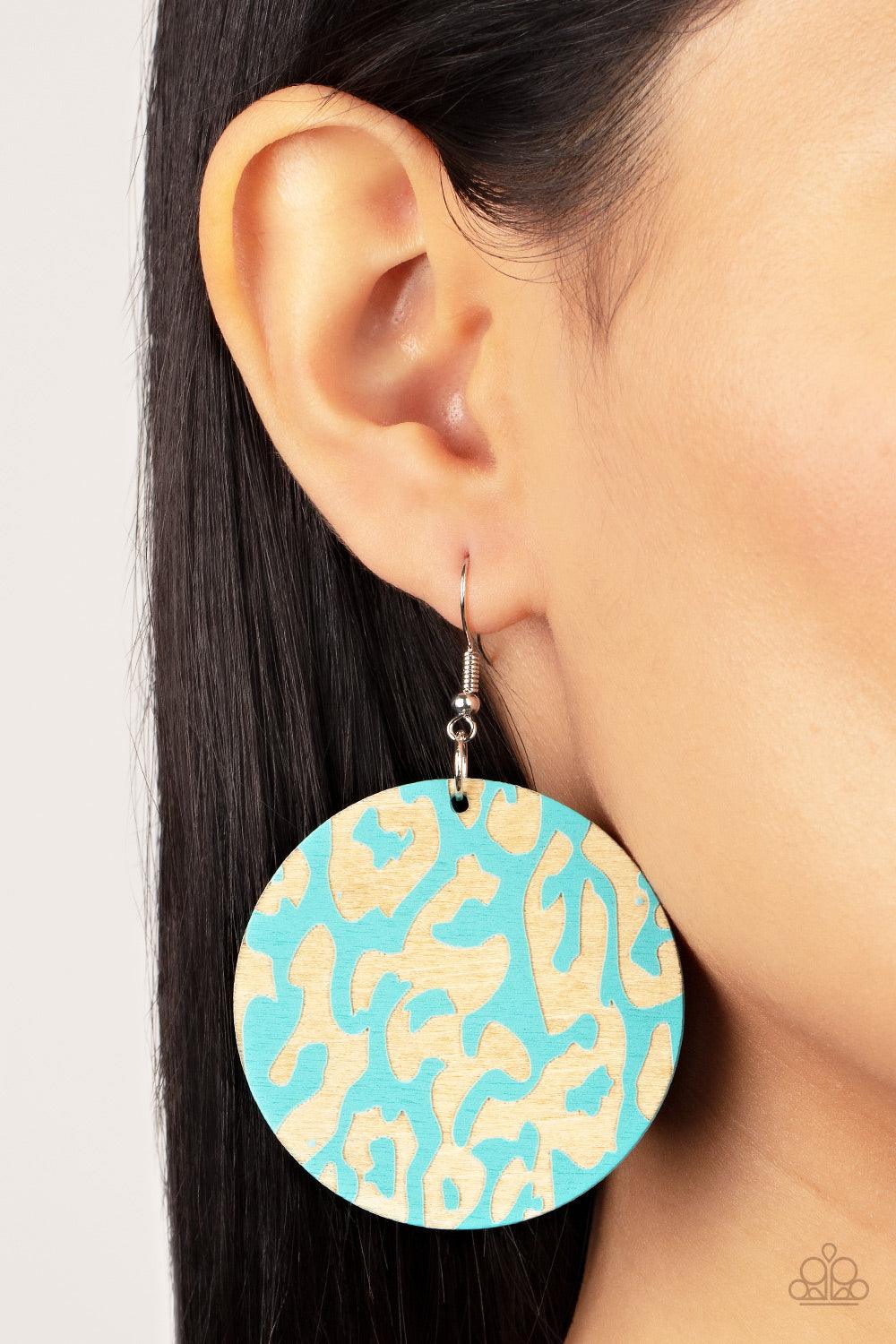 Paparazzi Accessories Catwalk Safari - Blue The front of a blue wooden disc is chiseled away, revealing a colorful cheetah-like pattern for a wild fashion. Earring attaches to a standard fishhook fitting. Sold as one pair of earrings. Jewelry