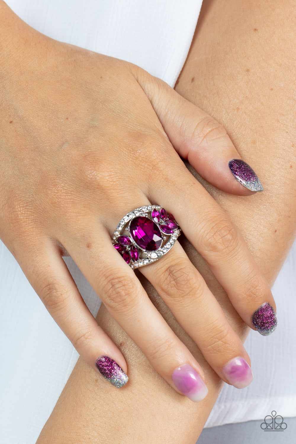 Paparazzi Accessories Cosmic Clique - Pink Bordered in dainty rows of glassy white rhinestones, leafy pink rhinestones bloom from a dramatically oversized pink oval rhinestone that coalesces into a glamorous centerpiece atop the finger. Features a stretch