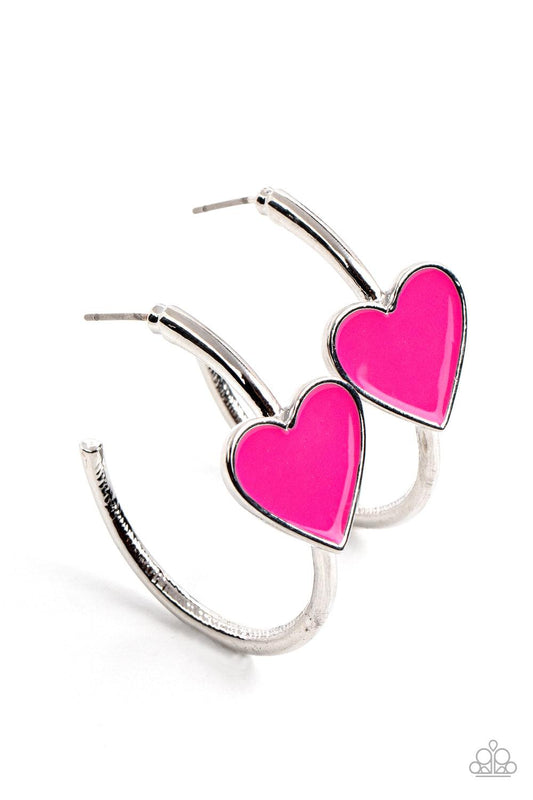 Paparazzi Accessories Kiss Up - Pink A charming Fuchsia Fedora heart adorns the front of a classic silver hoop resulting in a whimsical fashion. Earring attaches to a standard post fitting. Hoop measures approximately 1 1/4" in diameter. Sold as one pair