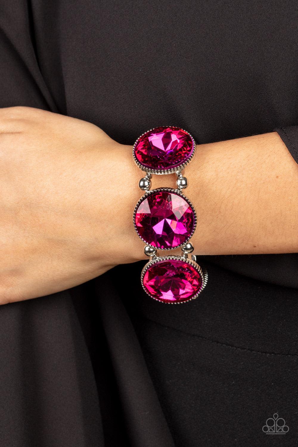 Paparazzi Accessories Powerhouse Hustle - Pink Infused with pairs of silver beads, a glitzy collection of dramatically oversized Fuchsia Fedora rhinestone frames are threaded along stretchy bands around the wrist for a jaw-dropping dazzle. Sold as one ind