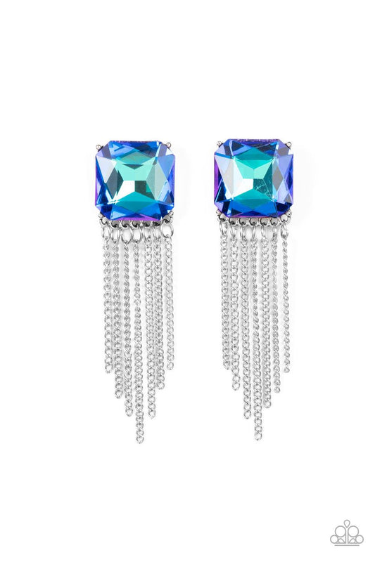 Paparazzi Accessories Supernova Novelty - Blue Featuring a stellar UV shimmer, an oversized radiant cut blue gem is pressed into a pronged silver fitting that gives way to a tapered curtain of silver chains for an out-of-this-world finish. Earring attache