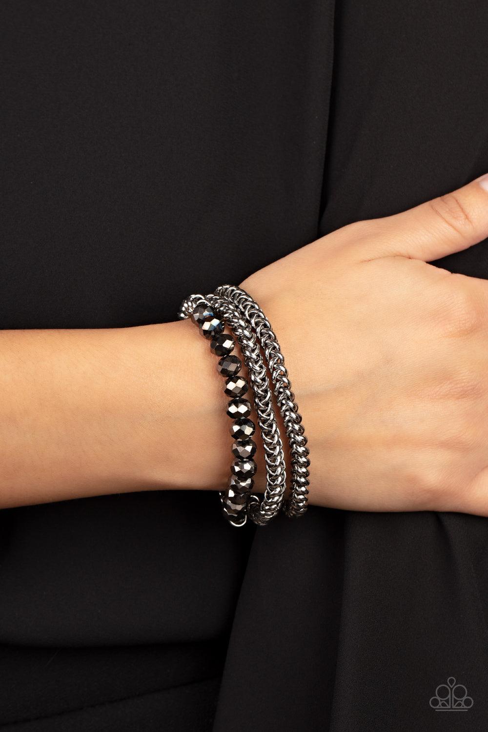 Paparazzi Accessories Gutsy and Glitzy - Silver Threaded along stretchy bands, sections of hematite crystal-like beads and interlocking silver chains layer around the wrist for a dash of glitzy grunge. Sold as one set of three bracelets. Jewelry