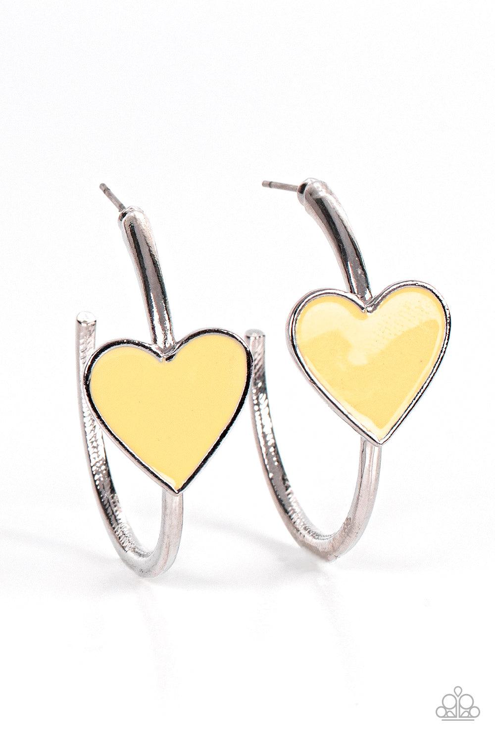 Paparazzi Accessories Kiss Up - Yellow A charming Illuminating heart adorns the front of a classic silver hoop resulting in a whimsical fashion. Earring attaches to a standard post fitting. Hoop measures approximately 1 1/4" in diameter. Sold as one pair