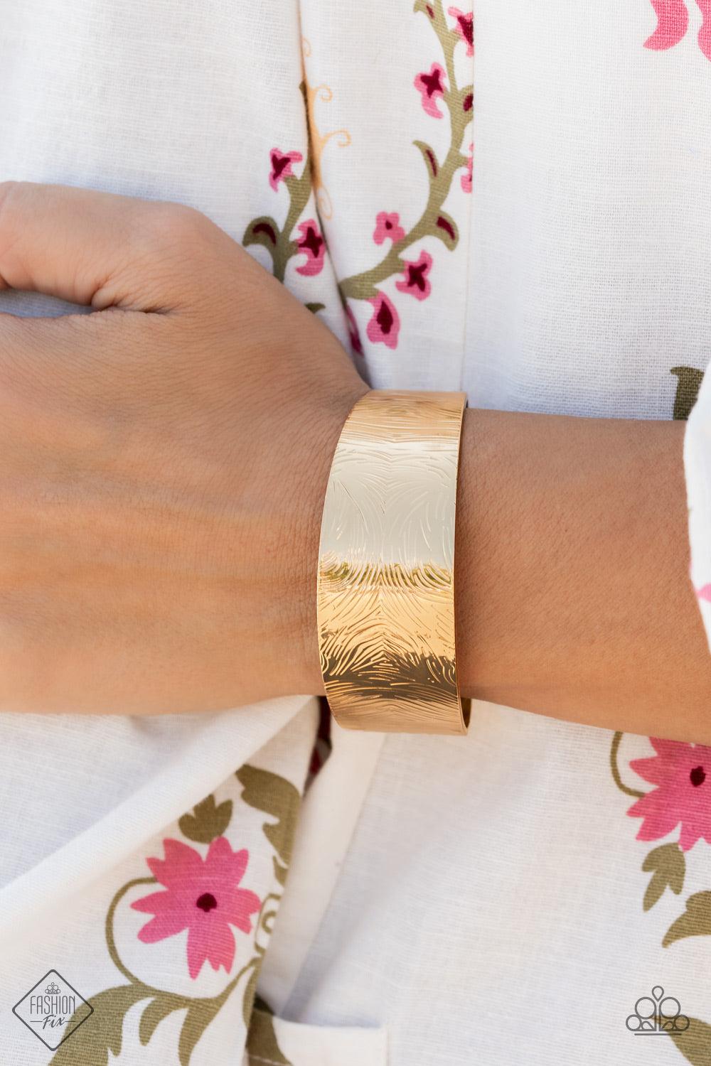 Paparazzi Accessories Coolly Curved - Gold A thick gold band is swirled with rippling textures as it wraps around the wrist into a bold cuff design. Sold as one individual bracelet. Jewelry