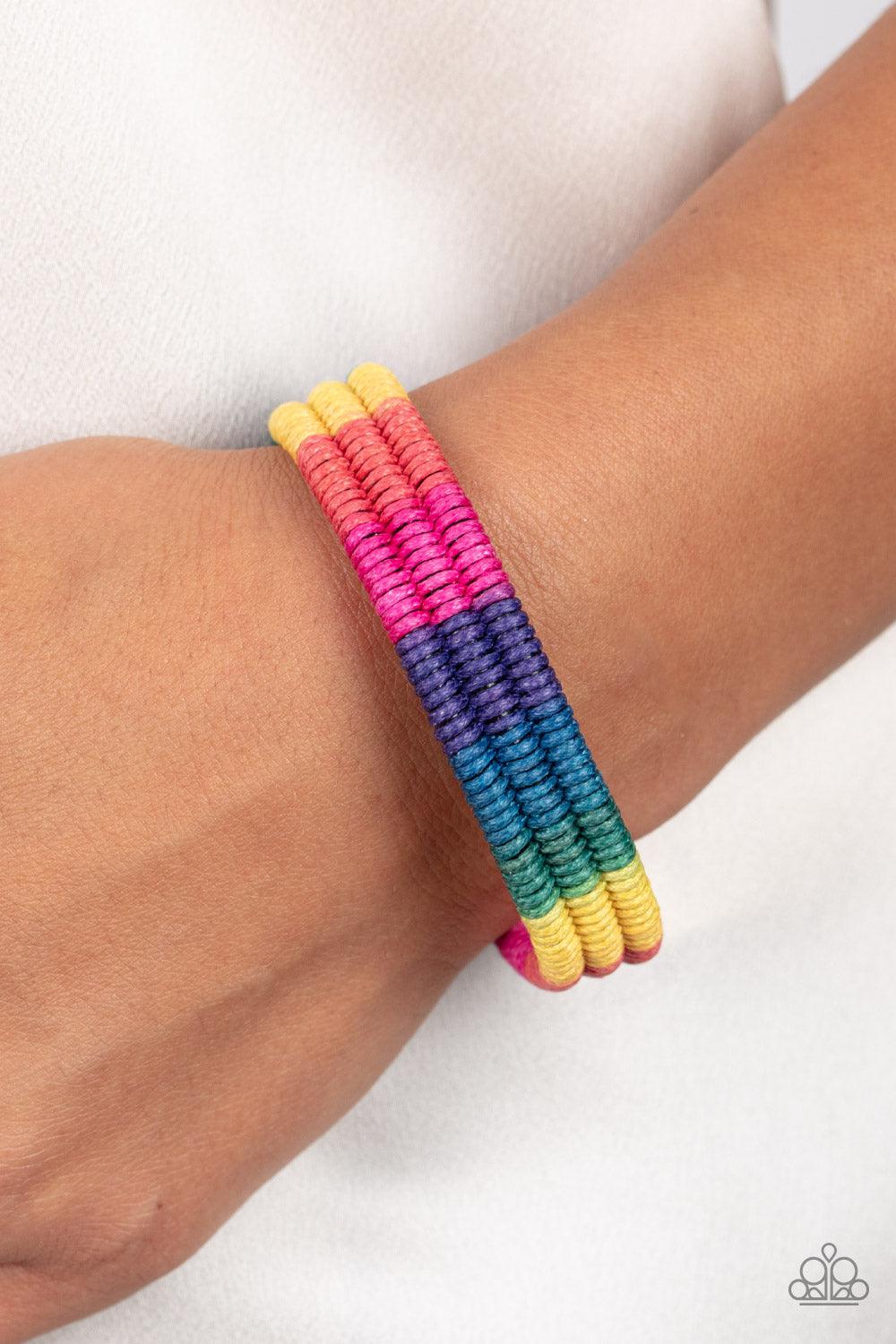 Paparazzi Accessories Rainbow Renegade - Multi Colorful sections of pink, red, yellow, green, blue, and purple cords ornately wrap and weave around three black bands, coalescing into a radiant rainbow around the wrist. Features an adjustable sliding knot