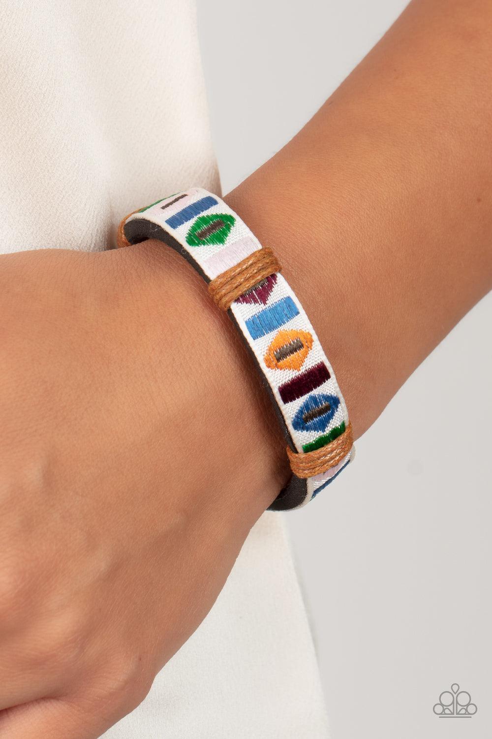 Paparazzi Accessories Textile Trendsetter - Multi A ribbon featuring a colorful geometric textile print is knotted in place across the front of a black leather band, creating a simply seasonal style around the wrist. Features an adjustable sliding knot cl