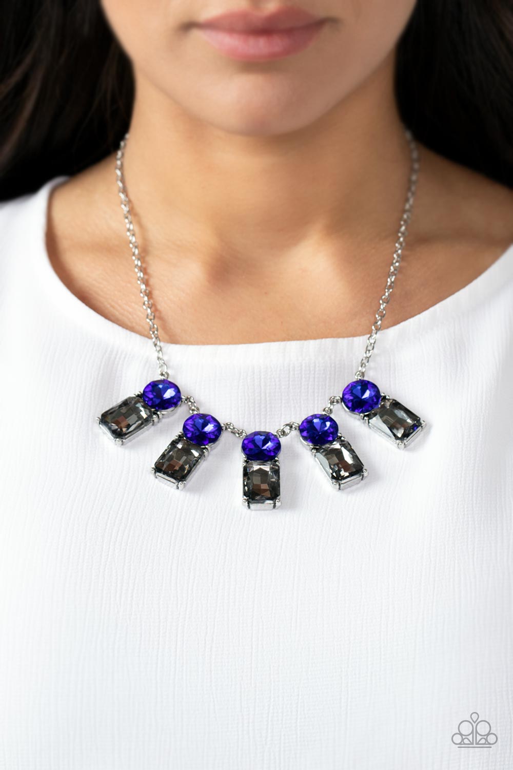Paparazzi Accessories Celestial Royal - Blue A sparkly row of oversized blue gems regally sit atop emerald cut smoky rhinestone bases as they delicately link along a dainty silver chain below the collar, resulting in a royal glamorous centerpiece. Feature