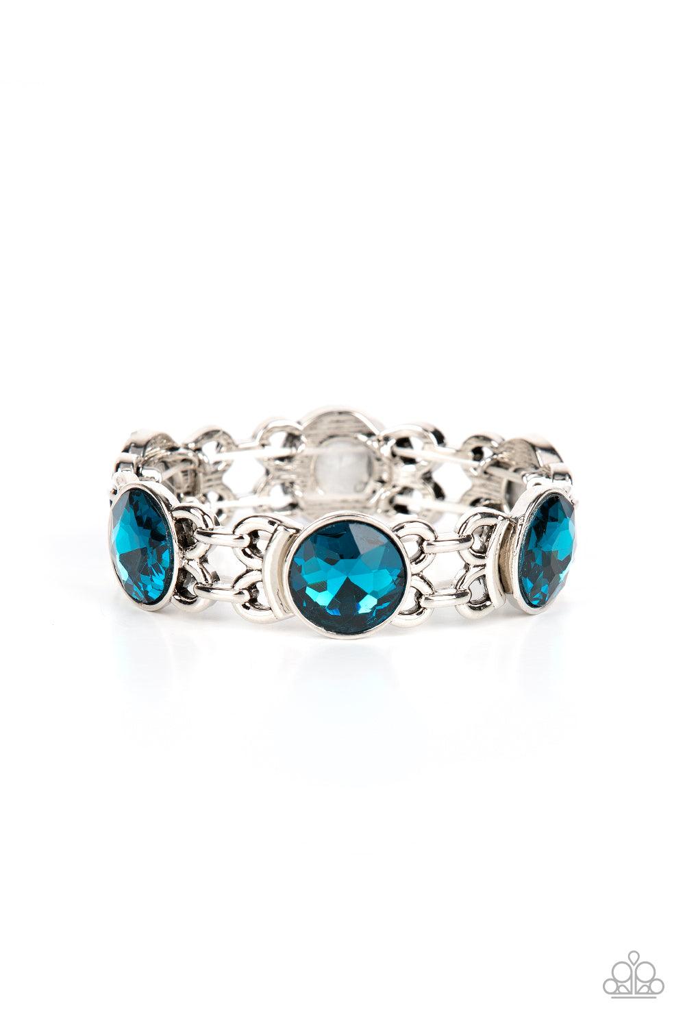 Paparazzi Accessories Devoted to Drama - Blue Featuring edgy chain-like fittings, a sparkly series of oversized blue rhinestones are threaded along stretchy bands around the wrist for a dramatic pop of glitz. Sold as one individual bracelet. Jewelry