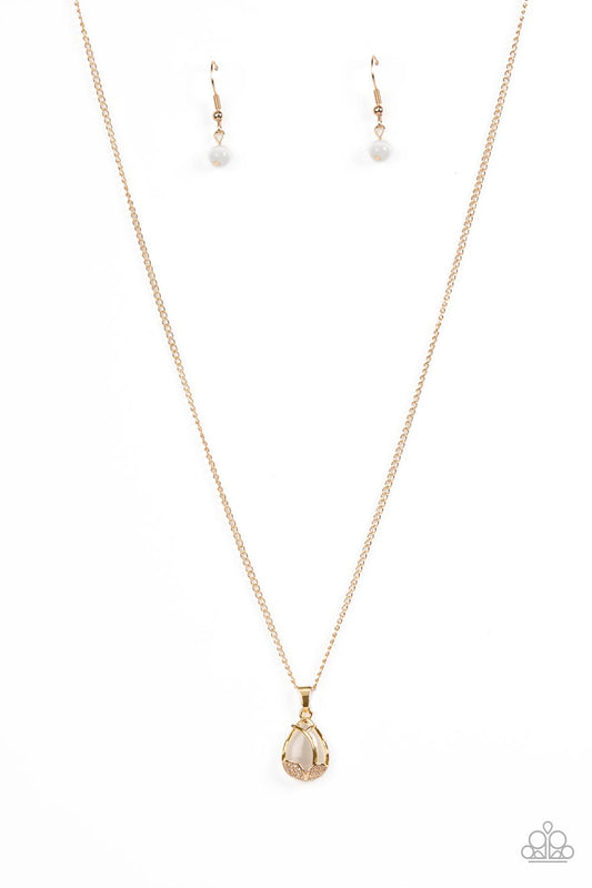 Paparazzi Accessories Top-Notch Trinket - Gold Dotted in dainty gold studs and glittery white rhinestones, leafy gold frames delicately fold around the bottom of a white cat's eye stone teardrop, resulting in an ethereal pendant below the collar. Features