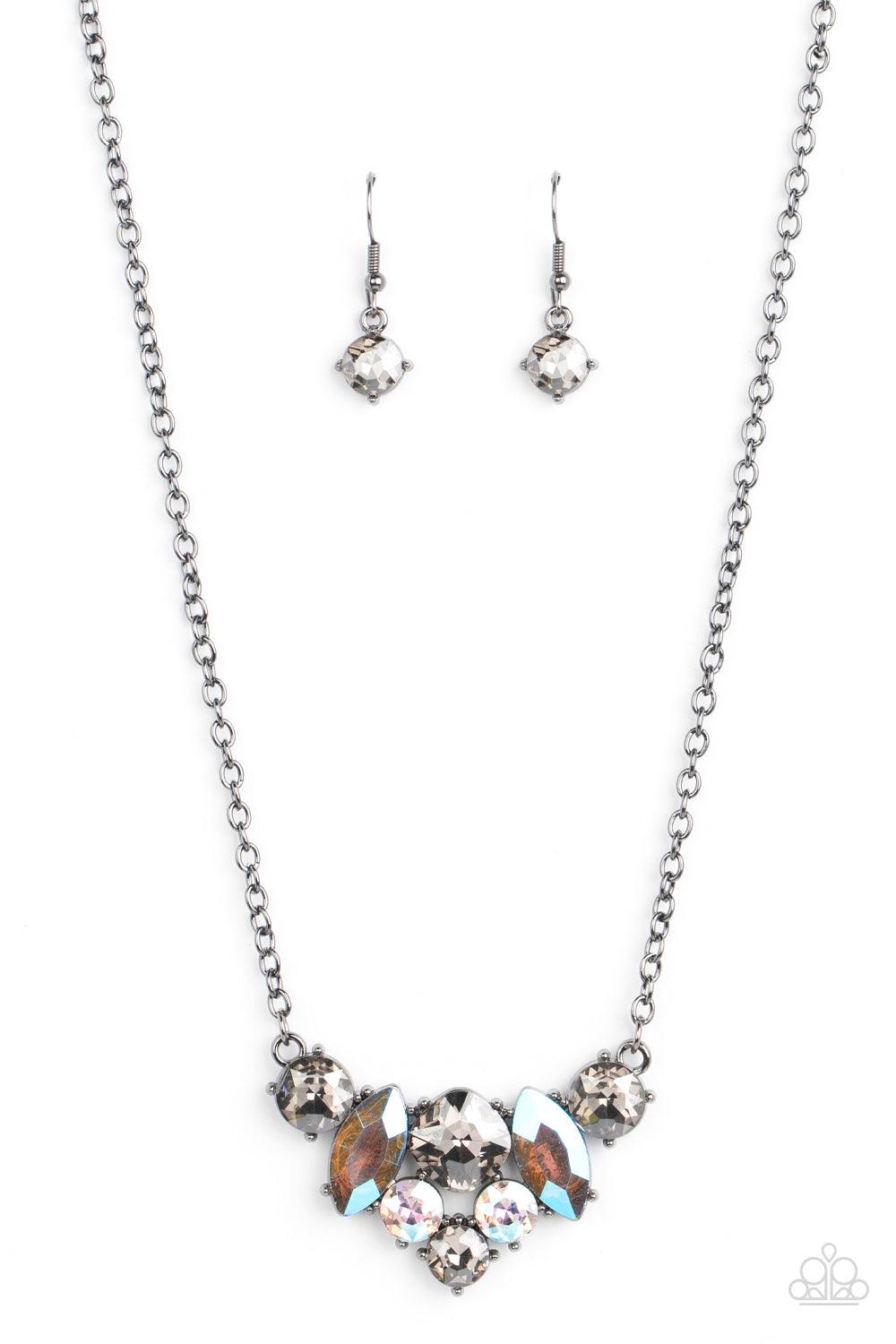 Paparazzi Accessories Lavishly Loaded - Black A smoldering collection of smoky, iridescent, and metallic gems of various cuts coalesces into a lavish frame at the bottom of a classic gunmetal chain, resulting in a glamorous finish below the collar. Sold a