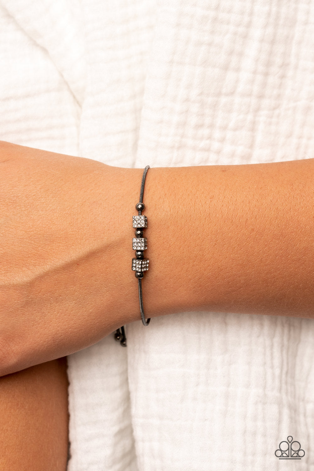 Paparazzi Accessories Roll Out the Radiance - Black Dainty gunmetal beads and white rhinestone encrusted gunmetal cubes slide along a rounded gunmetal snake chain around the wrist, resulting in a radiant centerpiece. Features an adjustable sliding bead cl