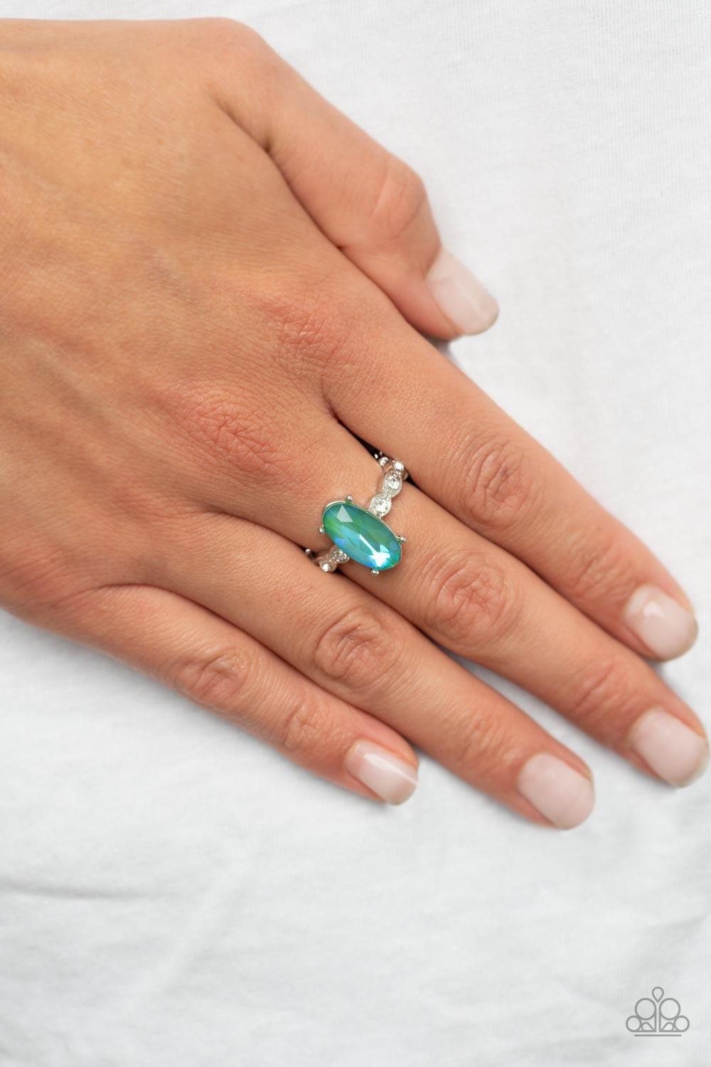 Paparazzi Accessories Stellar Sensation - Green Featuring a blue UV finish, an iridescent green oval rhinestone is nestled inside a pronged silver frame atop a dainty band of white rhinestones for a stellar fashion. Features a dainty stretchy band for a f