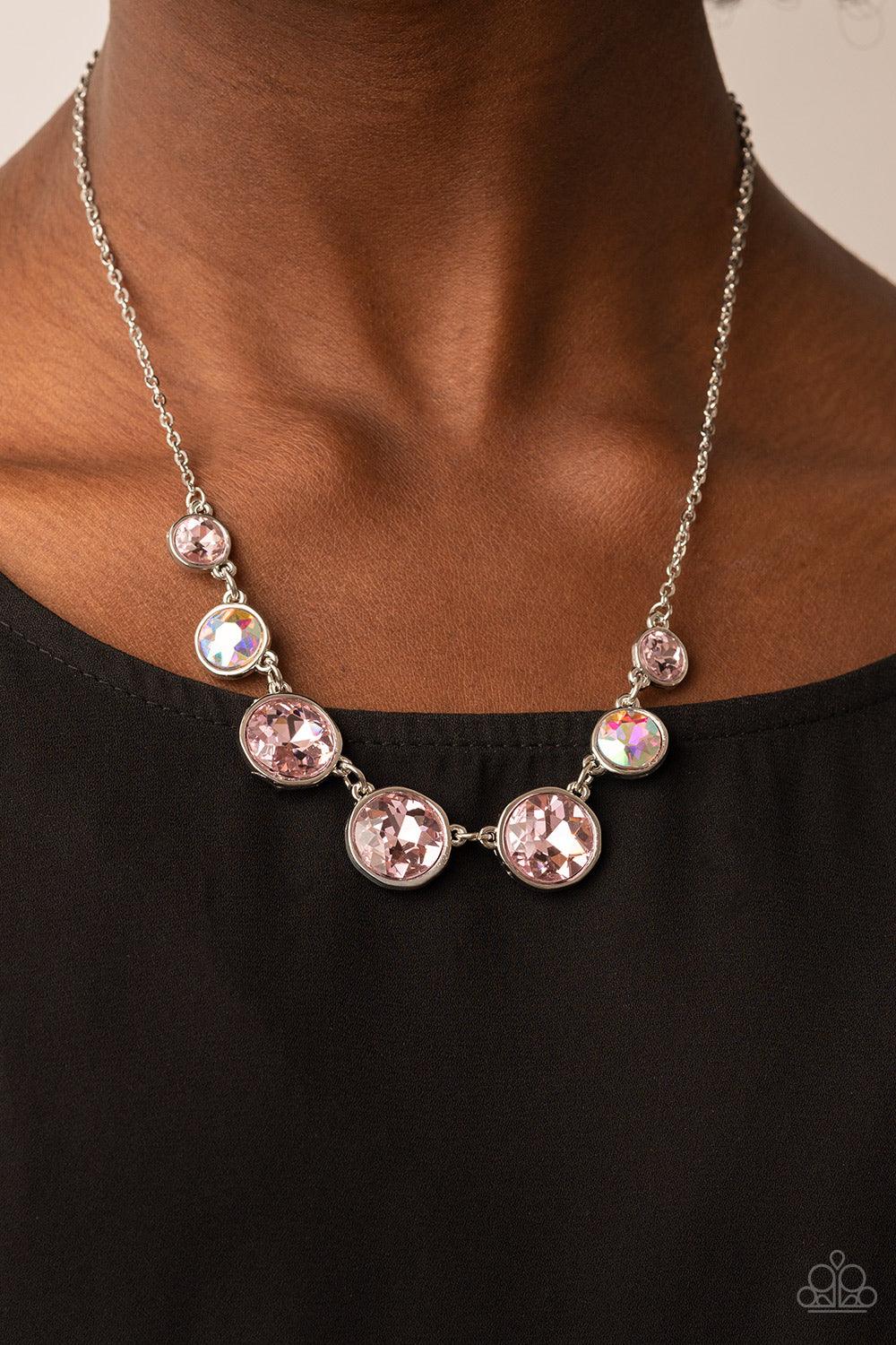 Paparazzi Accessories Pampered Powerhouse - Pink Encased in shiny silver frames, a glitzy collection of pink and iridescent gems gradually increase in size as they link below the collar for a flawless finish. Features an adjustable clasp closure. Sold as