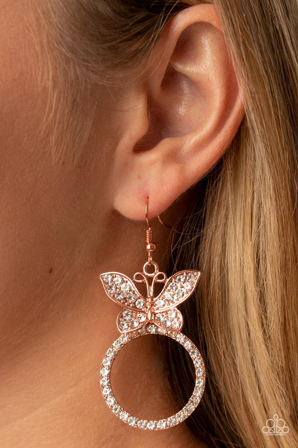 Paparazzi Accessories Paradise Found - Copper A white rhinestone encrusted shiny copper butterfly flutters atop a shiny copper ring dotted in matching white rhinestones, resulting in a dazzling statement piece. Earring attaches to a standard fishhook fitt