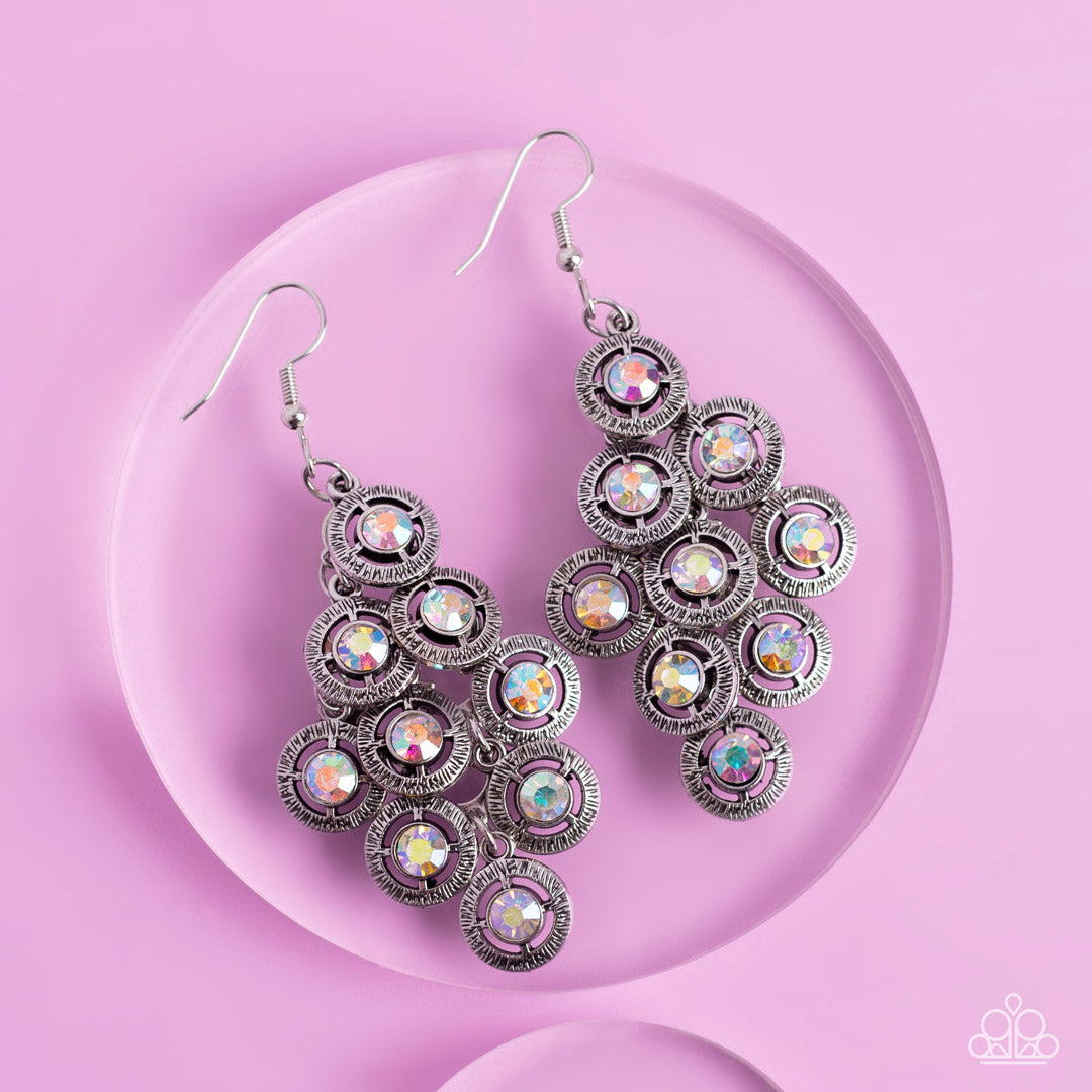 Paparazzi Accessories Constellation Cruise - Multi Dotted with iridescent rhinestone centers, tiers of textured silver frames cascade from a metallic backdrop for a stellar tasseled look. Earring attaches to a standard fishhook fitting. Sold as one pair o