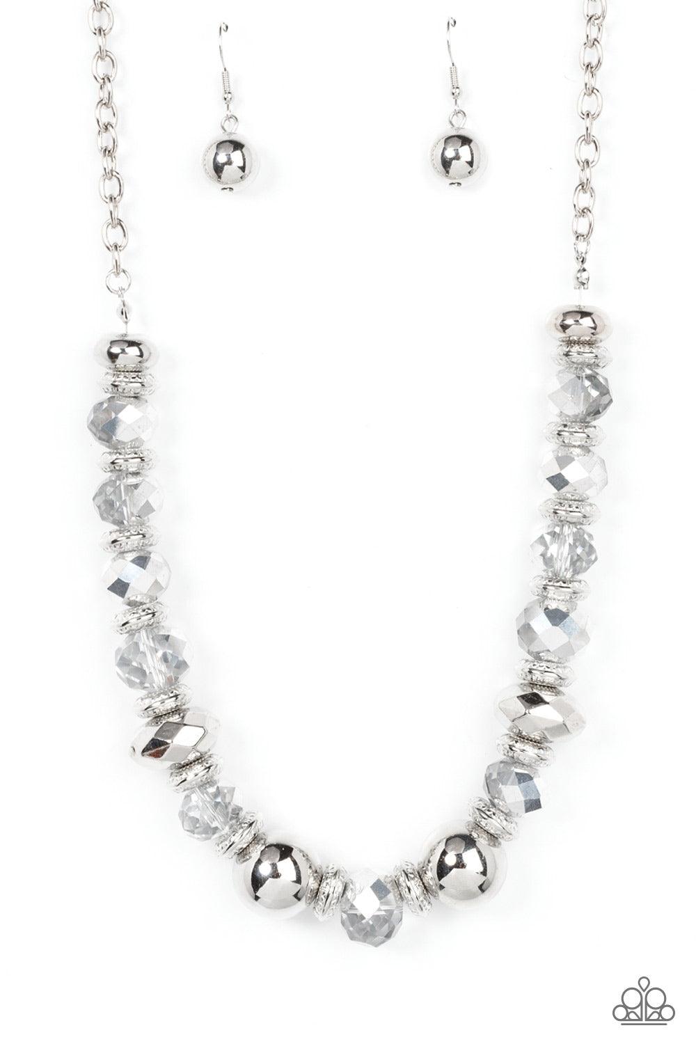 Paparazzi Accessories Interstellar Influencer - Silver A dramatic assortment of oversized silver beads, textured silver rings, and faceted metallic flecked gems delicately glides along an invisible wire below the collar, resulting in a stellar sparkle. Fe