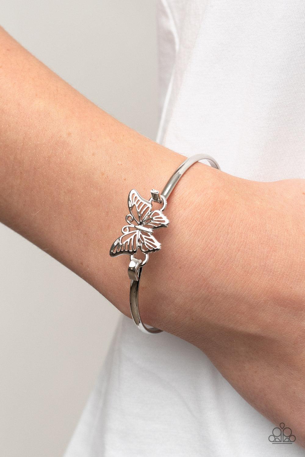 Paparazzi Accessories Did I FLUTTER? - Silver Attached to a shiny silver bangle-like bracelet, a silver butterfly flutters atop the wrist for a dainty fashion. Features a hook and eye closure. Sold as one individual bracelet. Bracelets