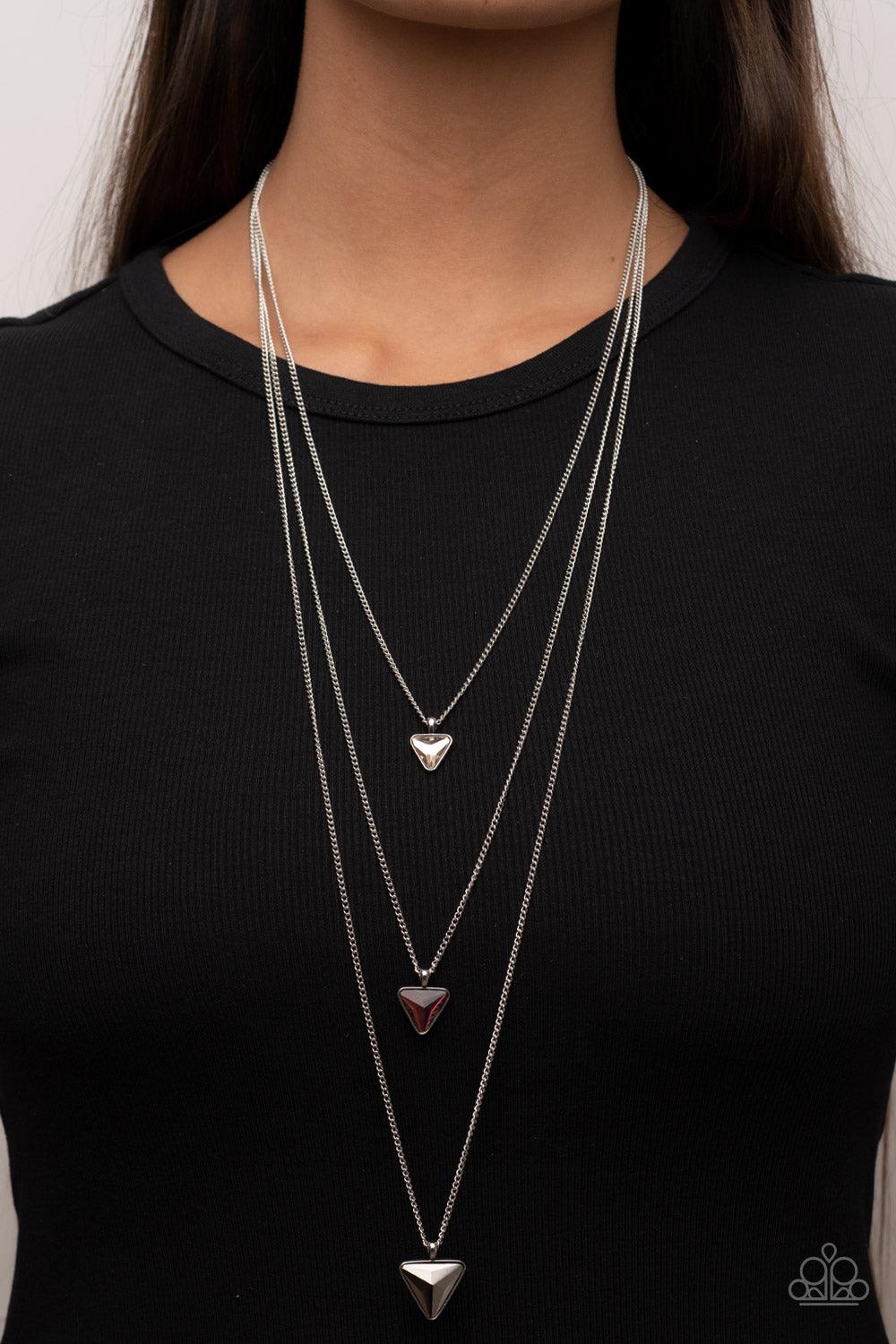 Paparazzi Accessories Follow the LUSTER - Multi Glassy white, oil spill, and hematite triangular gems gradually increase in size as they swing from the bottoms of extended silver chains, layering into an edgy shimmer across the chest. Features an adjustab