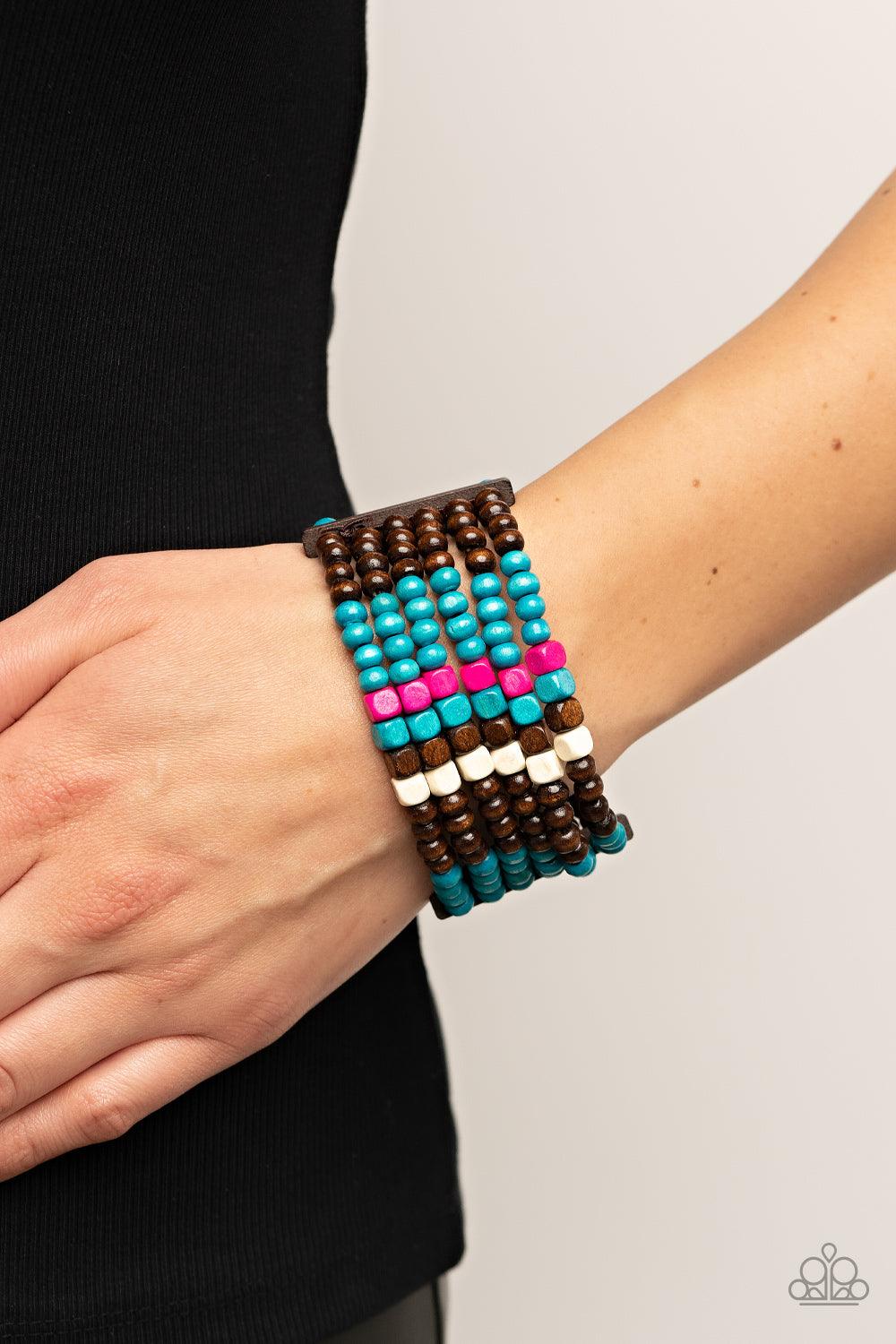 Paparazzi Accessories Dive into Maldives - Blue Held together with rectangular wooden frames, a colorful collection of blue, brown, white, and Fuchsia Fedora cube and round wooden beads are threaded along stretchy bands around the wrist for a splash of tr