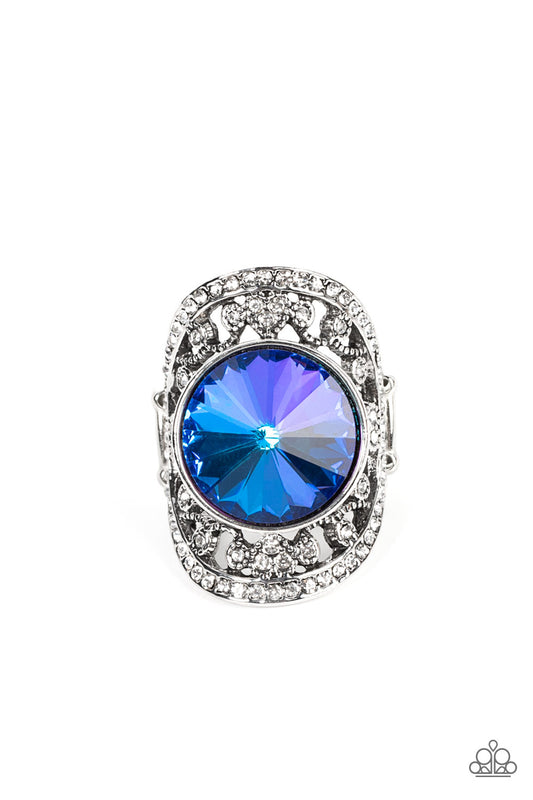 Paparazzi Accessories Galactic Garden - Blue A dramatically oversized, iridescent blue gem is pressed into the center of an oval silver frame dotted and bordered in glassy white rhinestones, resulting in a sparkly filigree-filled centerpiece atop the fing