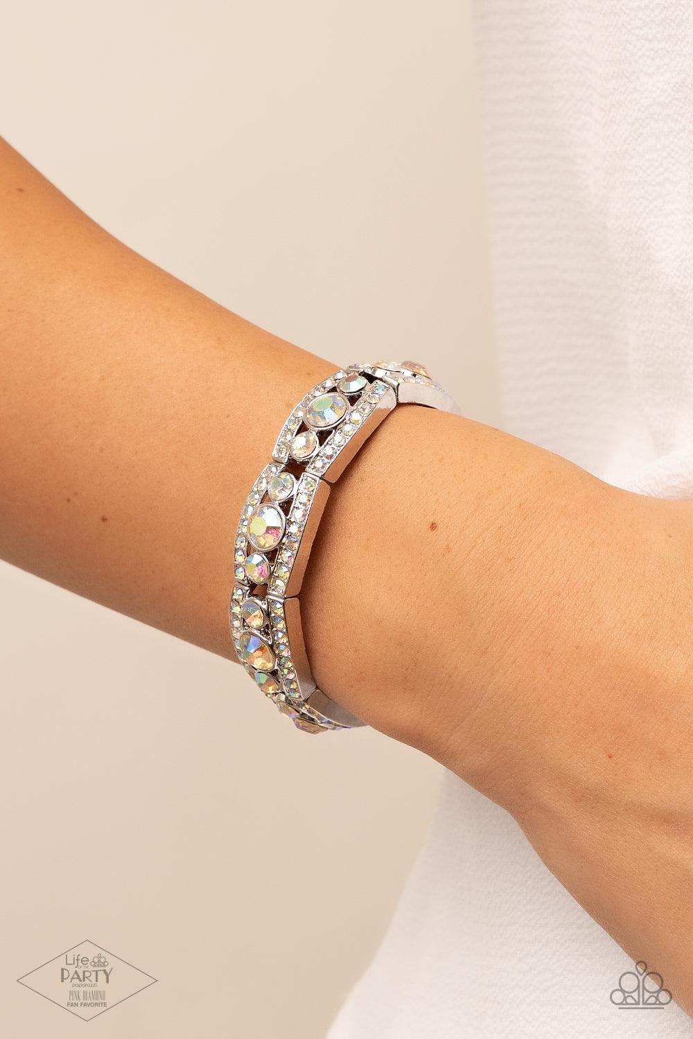 Paparazzi Accessories Easy On The ICE - Multi Iridescent rhinestone encrusted silver bars flank a dazzling trio of oversized iridescent rhinestones, coalescing into a glittery frame. The sparkly frames are threaded along stretchy bands around the wrist, c