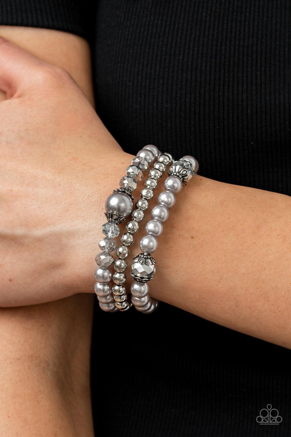 Paparazzi Accessories Positively Polished - Silver Stretchy silver pearl and silver beaded bracelets are adorned with ornate silver accents and glassy hematite flecked crystal-like beads, creating polished layers around the wrist. Sold as one set of three