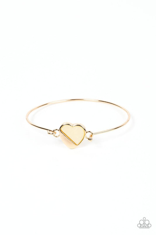 Paparazzi Accessories Hidden Intentions - Gold A glistening gold plate slants across a white shell-like heart charm that delicately hinges to a dainty gold bangle-like bracelet, creating a charming centerpiece around the wrist. Features a barbell closure.