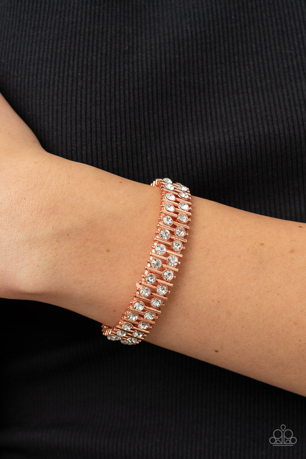 Paparazzi Accessories Generational Glimmer - Copper Attached to shiny copper bars, a staggered display of solitaire white rhinestones alternates along a stretchy band around the wrist for an unexpected pop of shimmer around the wrist. Sold as one individu