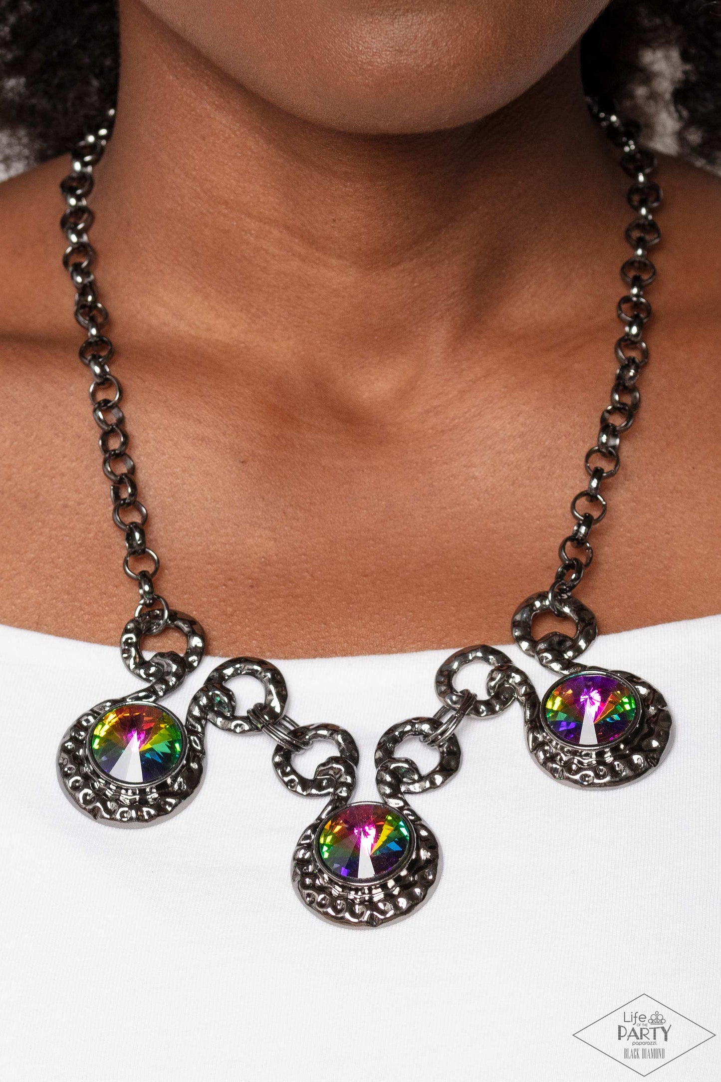 Paparazzi Accessories Hypnotized - Multi Three dramatically oversized oil spill rhinestones are nestled into three textured gunmetal fittings that are connected by oval gunmetal rings, creating a brilliant statement piece. Features an adjustable clasp clo