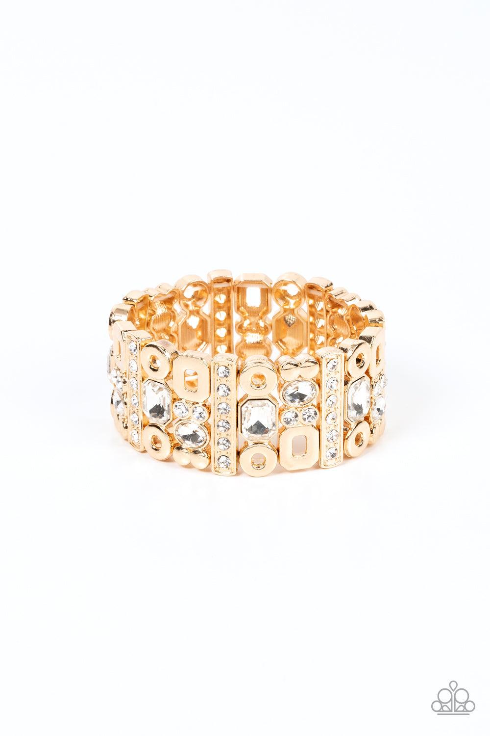 Paparazzi Accessories Dynamically Diverse - Gold Infused with flat gold studs and geometric gold accents, a mismatched assortment of oval, round, and emerald style white rhinestones coalesce into edgy frames along a stretchy band for an intense sparkle ar
