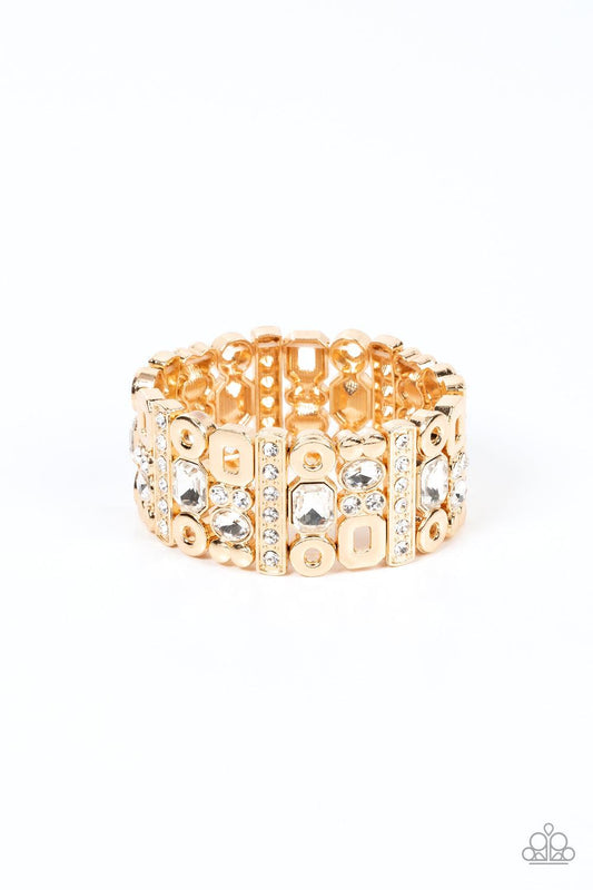 Paparazzi Accessories Dynamically Diverse - Gold Infused with flat gold studs and geometric gold accents, a mismatched assortment of oval, round, and emerald style white rhinestones coalesce into edgy frames along a stretchy band for an intense sparkle ar