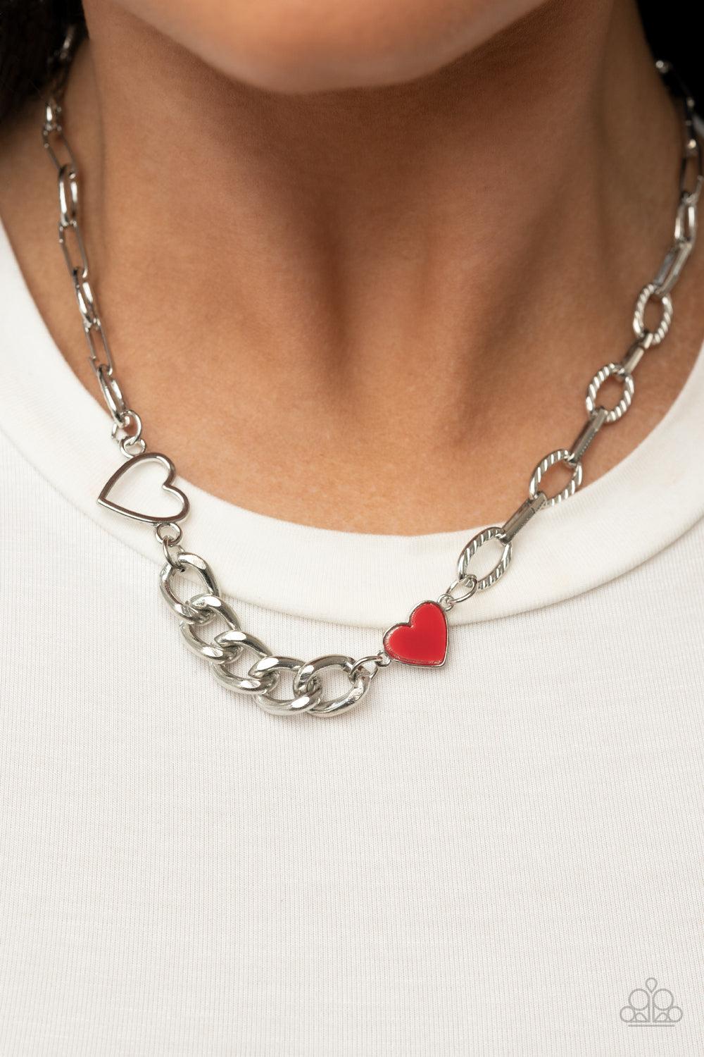 Paparazzi Accessories Little Charmer - Red A pair of shiny silver and red hearts asymmetrically adorn sections of mismatched silver chain, resulting in a flirtatious pop of color below the collar. Features an adjustable clasp closure. Sold as one individu