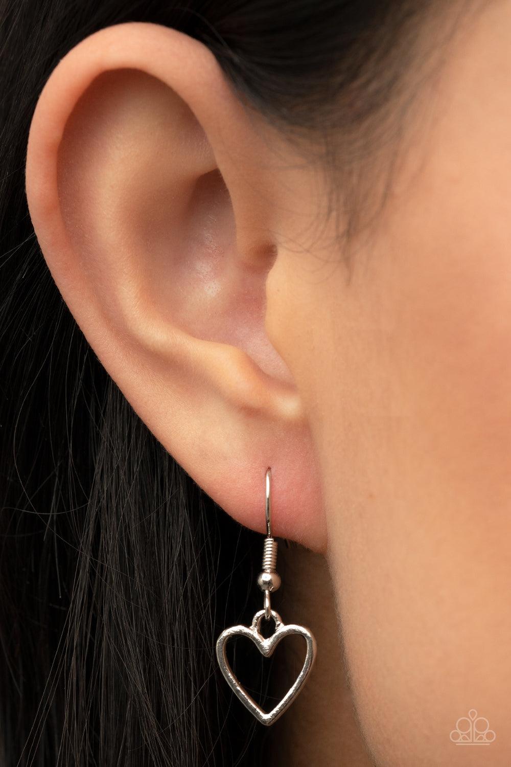 Paparazzi Accessories Little Charmer - Purple A pair of shiny silver and purple hearts asymmetrically adorn sections of mismatched silver chain, resulting in a flirtatious pop of color below the collar. Features an adjustable clasp closure. Sold as one in