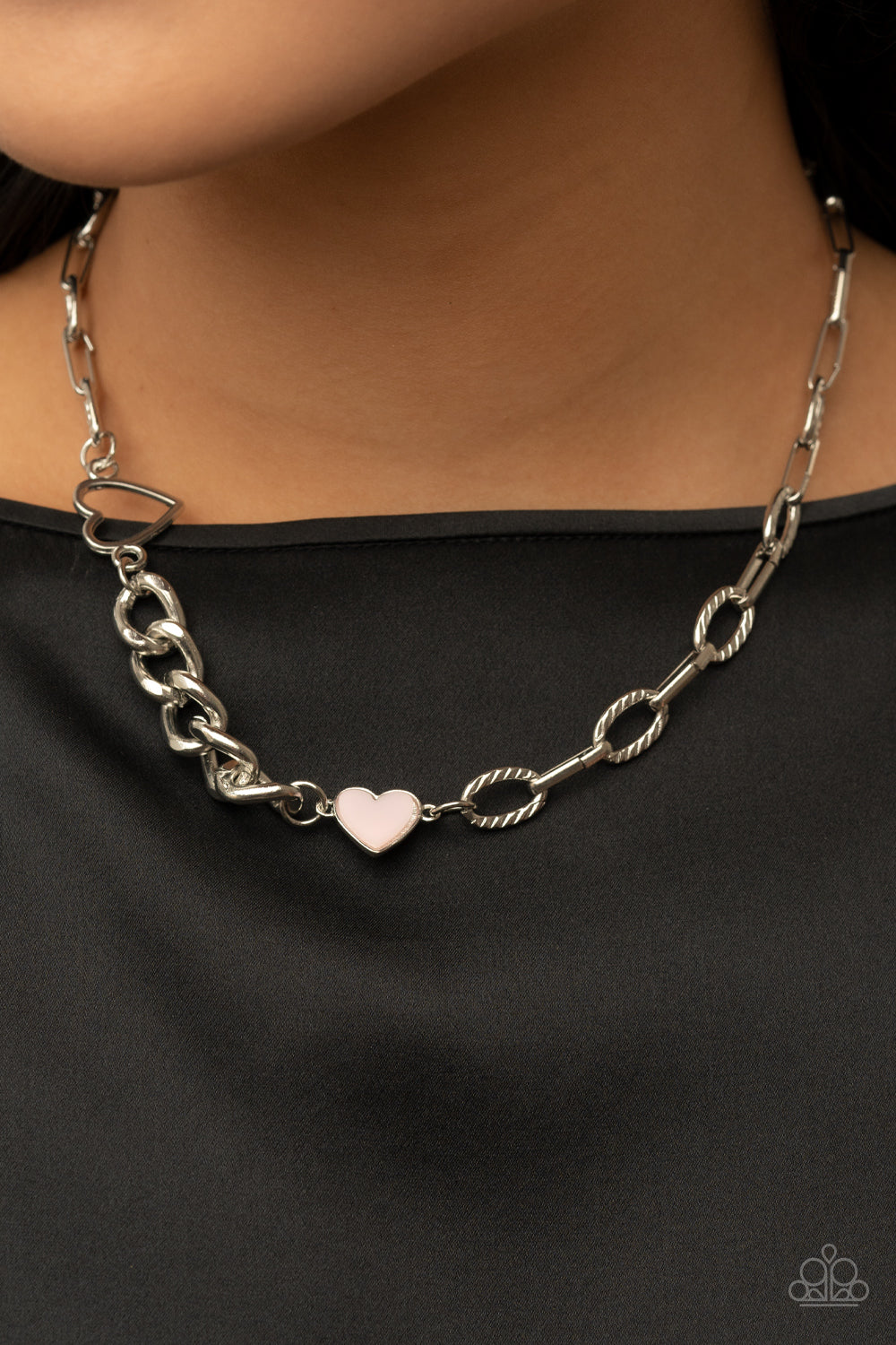 Paparazzi Accessories Little Charmer - Pink A pair of shiny silver and Pale Rosette hearts asymmetrically adorn sections of mismatched silver chain, resulting in a flirtatious pop of color below the collar. Features an adjustable clasp closure. Sold as on