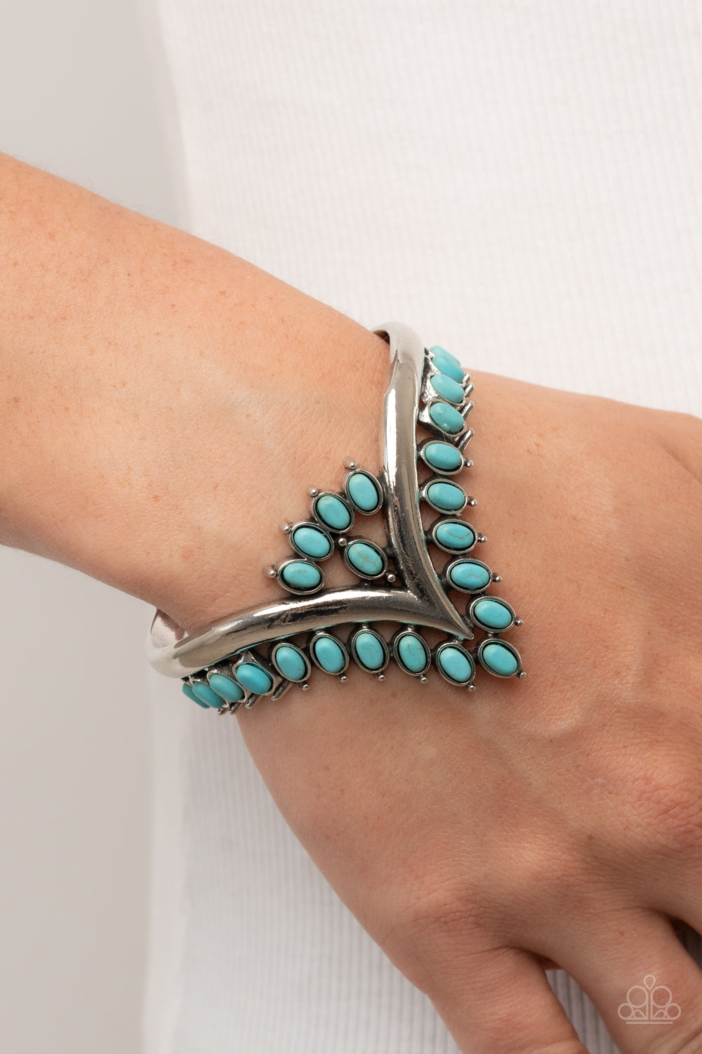 Paparazzi Accessories Teton Tiara - Blue Turquoise oval stones, encased in studded silver frames, line the edge of a daring V-shaped silver cuff. A gathering of turquoise stones adorns the center of the bracelet, adding a finishing touch to the rustically
