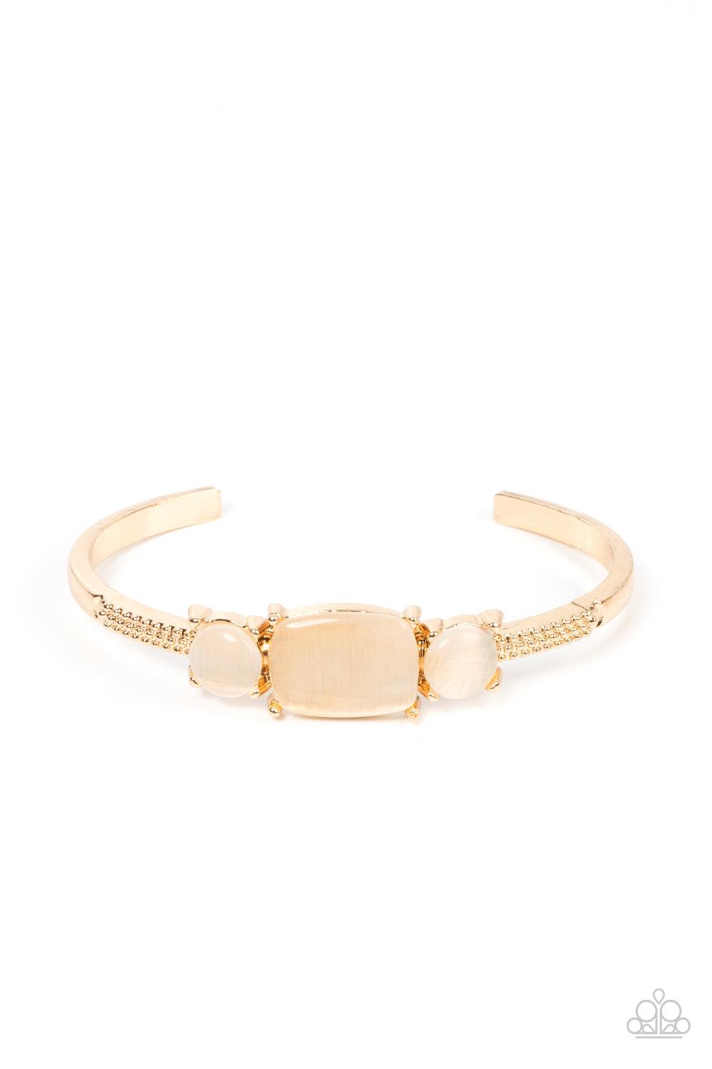 Paparazzi Accessories Tranquil Treasure - Gold A rectangular golden cat's eye stone is flanked by a pair of golden cat's eye stones atop a textured gold cuff, resulting in a dainty pop of color atop the wrist. Sold as one individual bracelet. Bracelets
