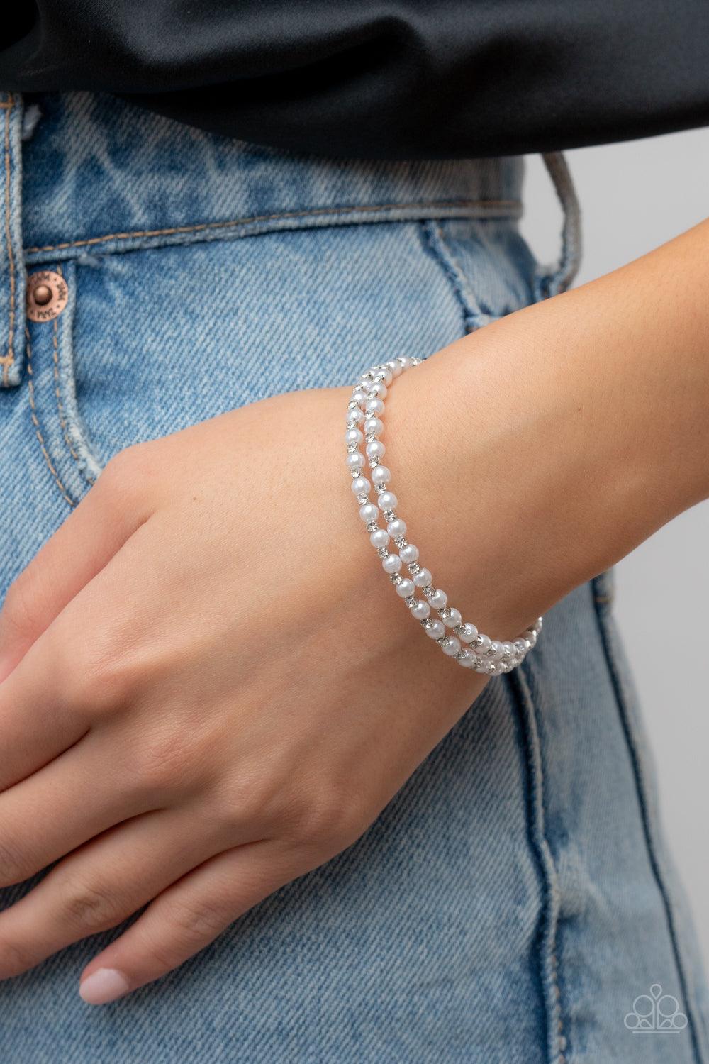 Paparazzi Accessories Regal Wraparound - White Dainty white pearls and white rhinestone dotted silver fittings alternate along an infinity wire around the wrist, resulting in wraparound shimmer. Sold as one individual bracelet. Jewelry