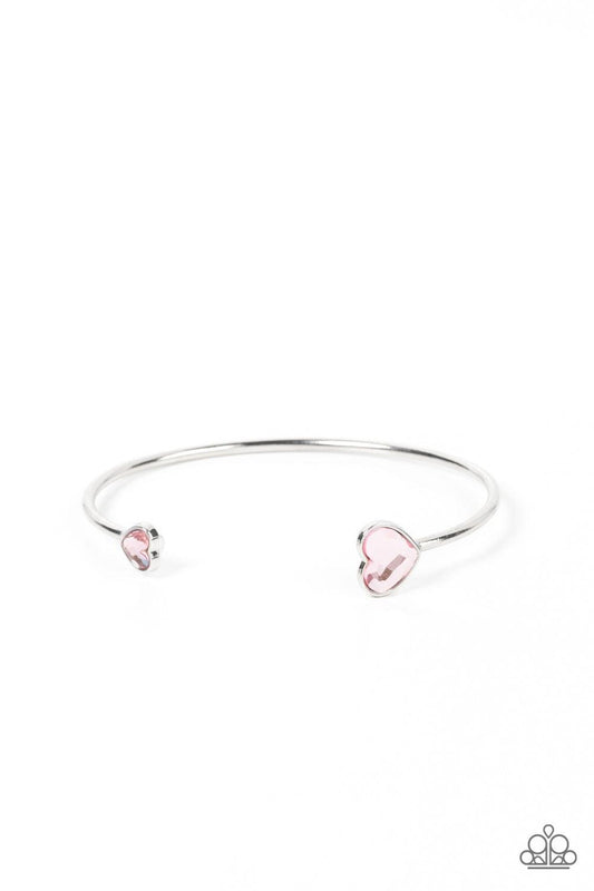 Paparazzi Accessories Unrequited Love - Pink Enhanced with glitzy pink rhinestones, two silver hearts adorn the ends of a silver band that curls around the wrist for a flirtatious open-faced style cuff. Sold as one individual bracelet. Bracelets