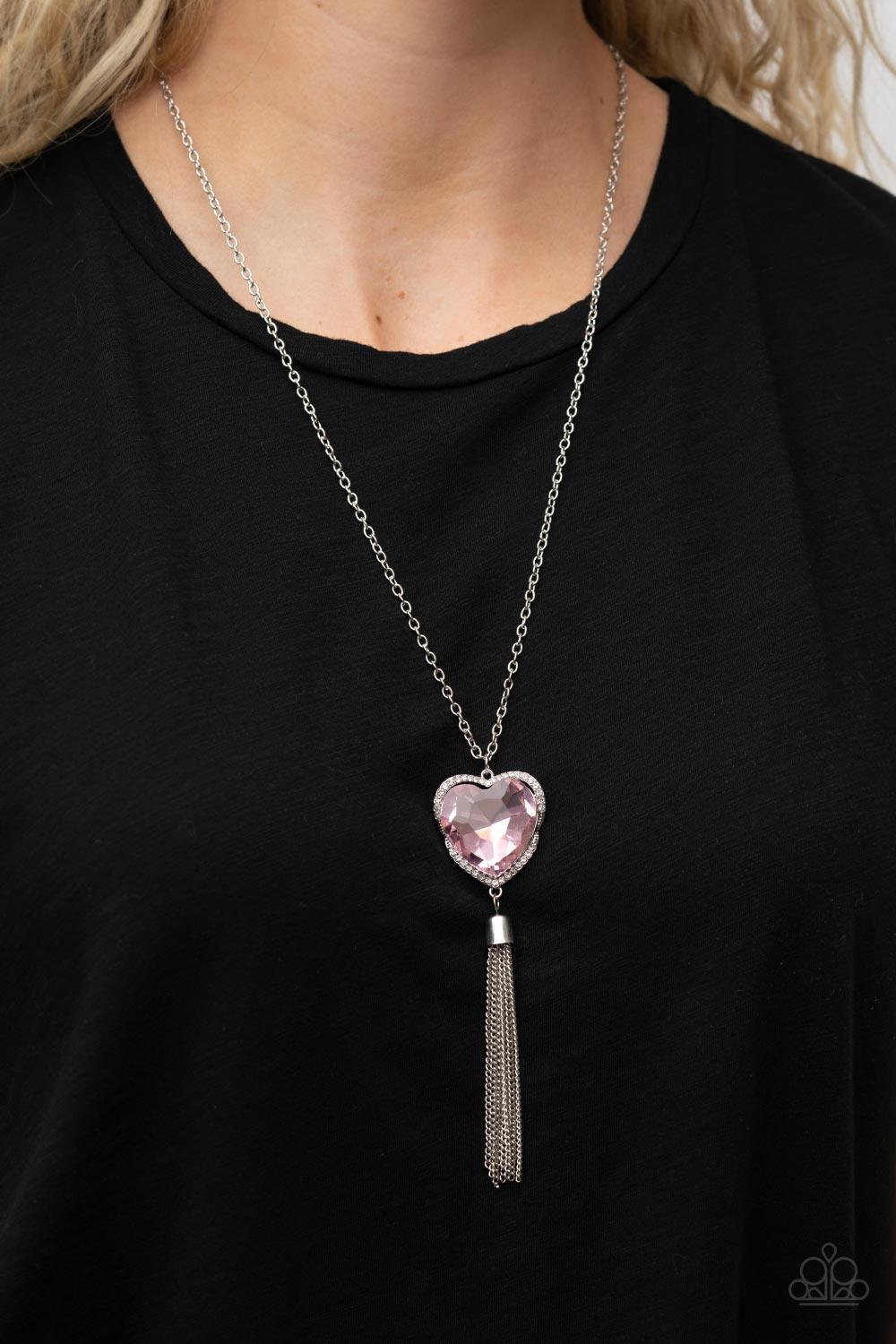 Paparazzi Accessories Finding My Forever - Pink Bordered in a ribbon of glassy white rhinestones, an oversized pink heart-shaped gem seemingly floats at the bottom of an extended silver chain. A shimmery silver chain tassel dances from the bottom of the s