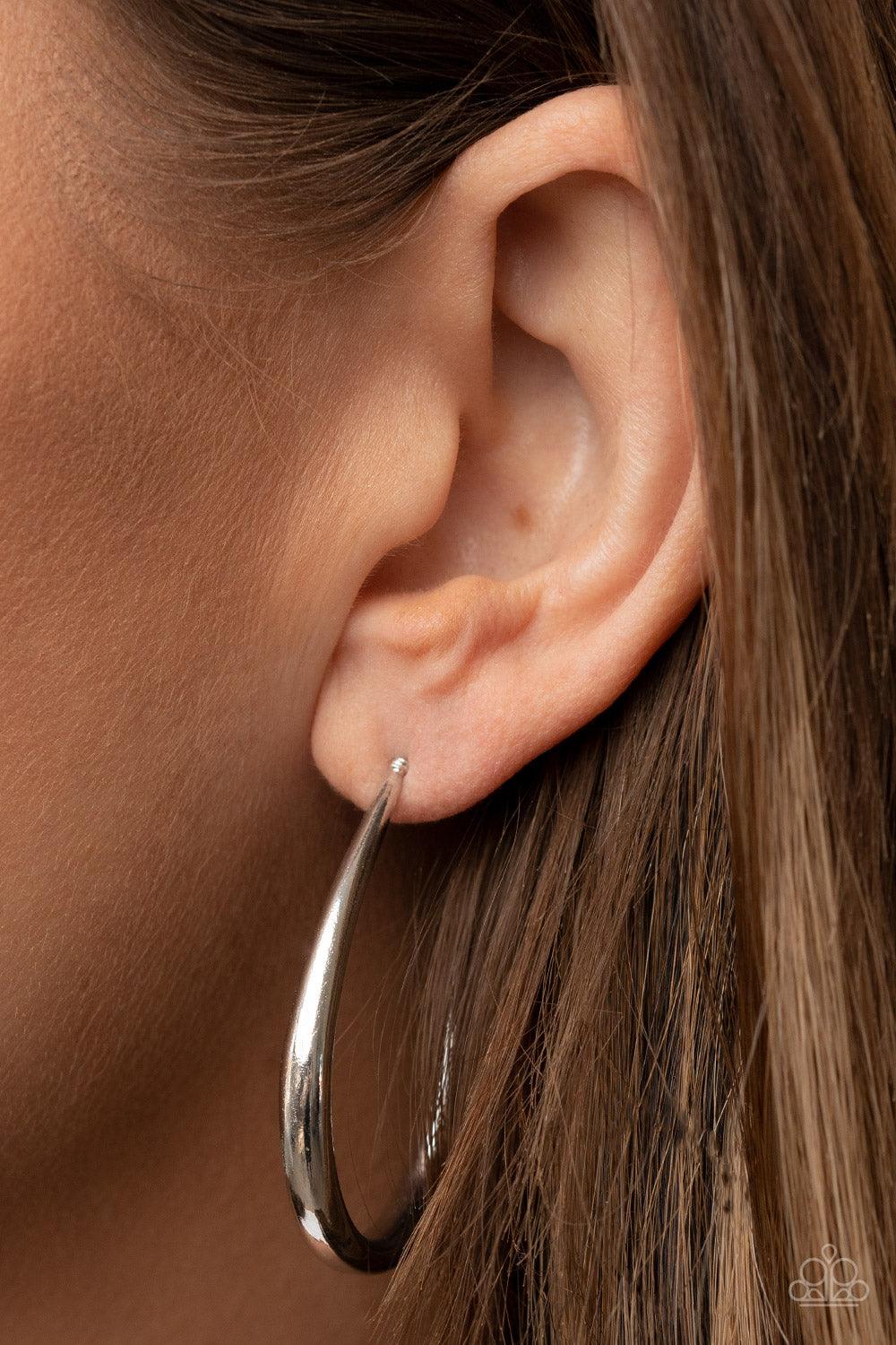 Paparazzi Accessories CURVE Your Appetite - Silver A shiny silver bar sharply curves into an asymmetrical hoop, adding a flash of metallic edge to any outfit. Earring attaches to a standard post fitting. Hoop measures approximately 1 1/4" in diameter. Sol