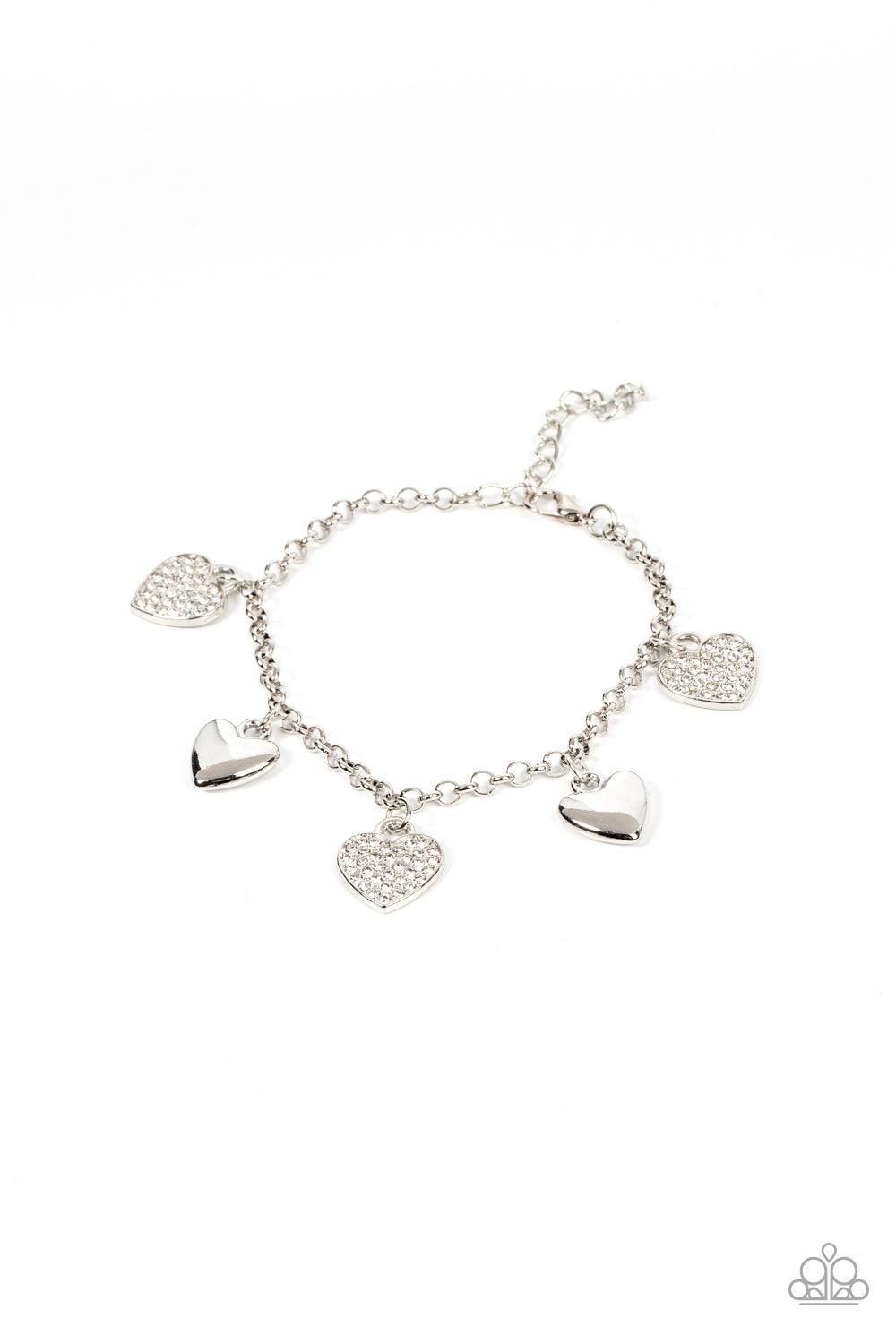 Paparazzi Accessories Lusty Lockets - White Shiny silver heart charms delicately alternate with white rhinestone encrusted heart frames along a silver chain around the wrist, resulting in a flirtatious fringe. Features an adjustable clasp closure. Sold as
