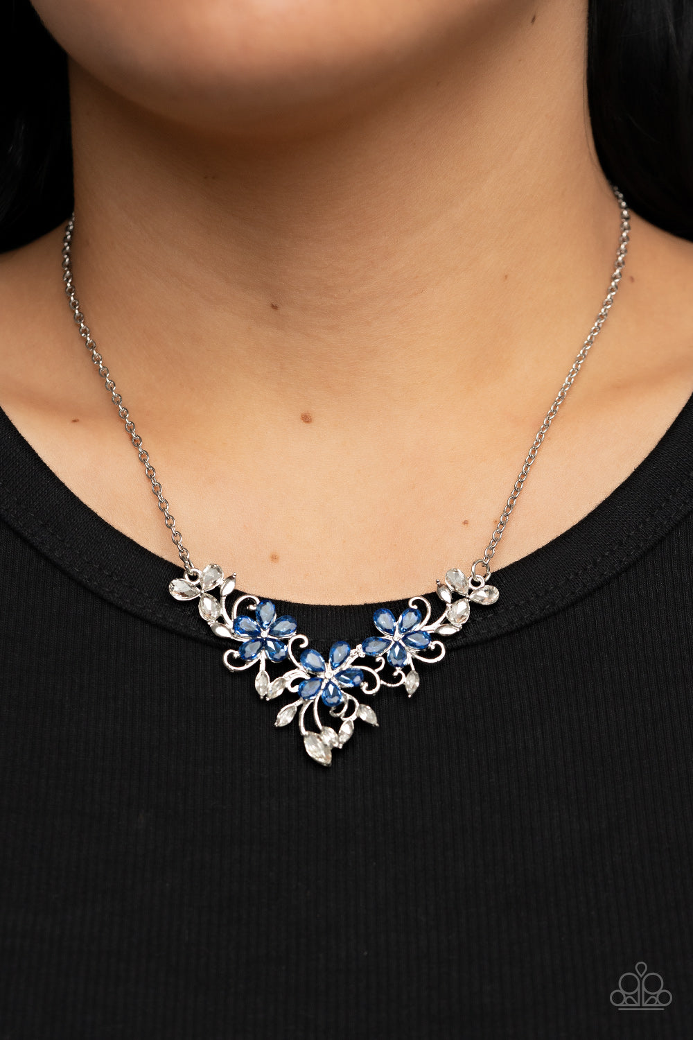 Paparazzi Accessories Floral Fashion Show - Blue A twinkly trio of blue rhinestone petaled flowers bloom atop a leafy silver backdrop adorned in marquise cut white rhinestones, resulting in a timeless floral centerpiece below the collar. Features an adjus