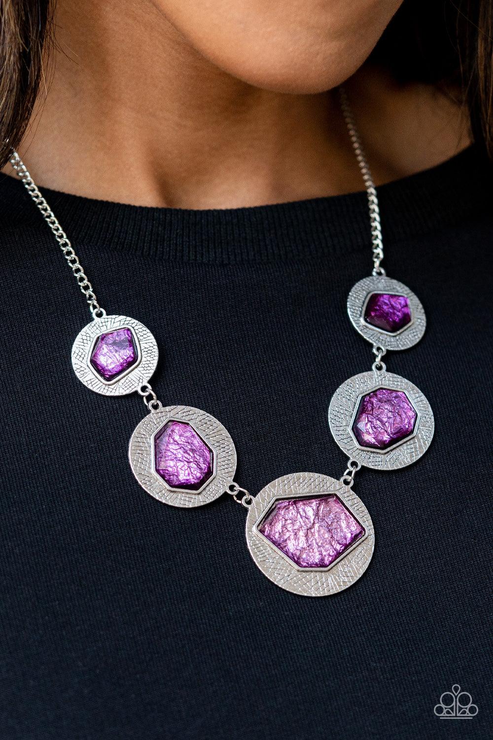 Paparazzi Accessories Raw Charisma - Purple Featuring a refracted shimmer, asymmetrical, glassy purple gems sparkle atop textured silver discs as they delicately link into an edgy statement piece below the collar. Features an adjustable clasp closure. Sol