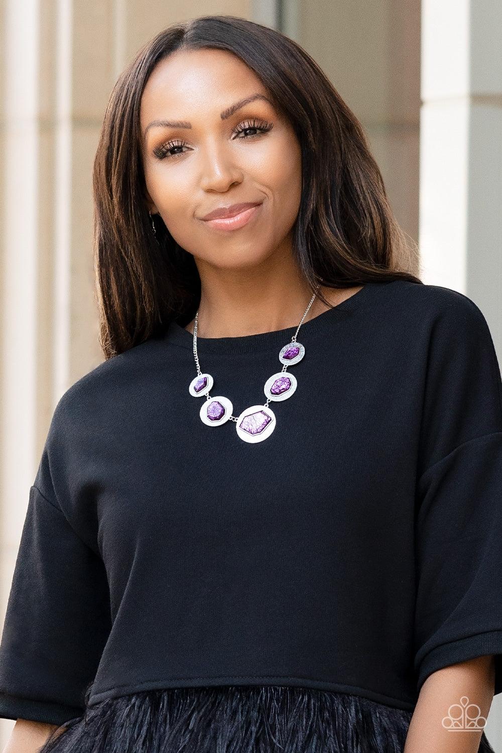 Paparazzi Accessories Raw Charisma - Purple Featuring a refracted shimmer, asymmetrical, glassy purple gems sparkle atop textured silver discs as they delicately link into an edgy statement piece below the collar. Features an adjustable clasp closure. Sol
