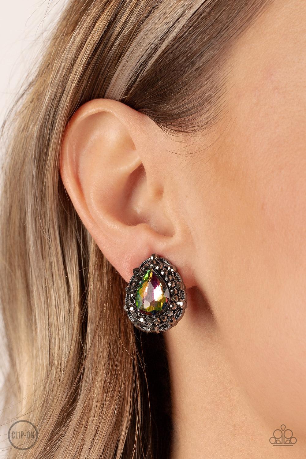 Paparazzi Accessories Haute Happy Hour - Multi *Clip-On An oversized oil spill teardrop gem is elegantly bordered in glitzy hematite rhinestones atop a decorative gunmetal frame, culminating into a smoldering twinkle. Earring attaches to a standard clip-o