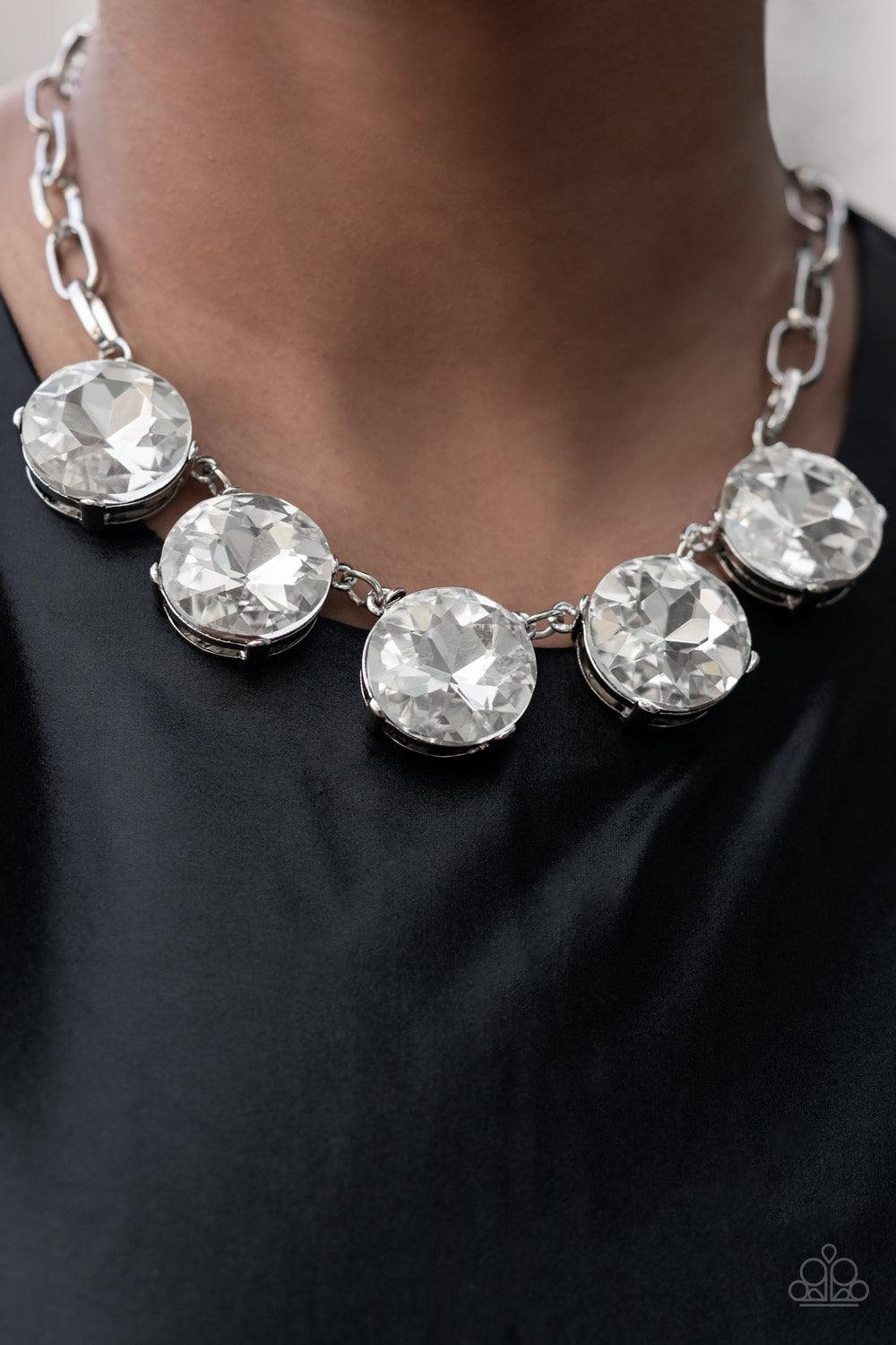 Paparazzi Accessories Limelight Luxury - White Set in silver pronged fittings, five dramatically oversized brilliant white rhinestones connect across the collar and attach to an oversized silver chain creating a stunning spot-light loving statement piece.