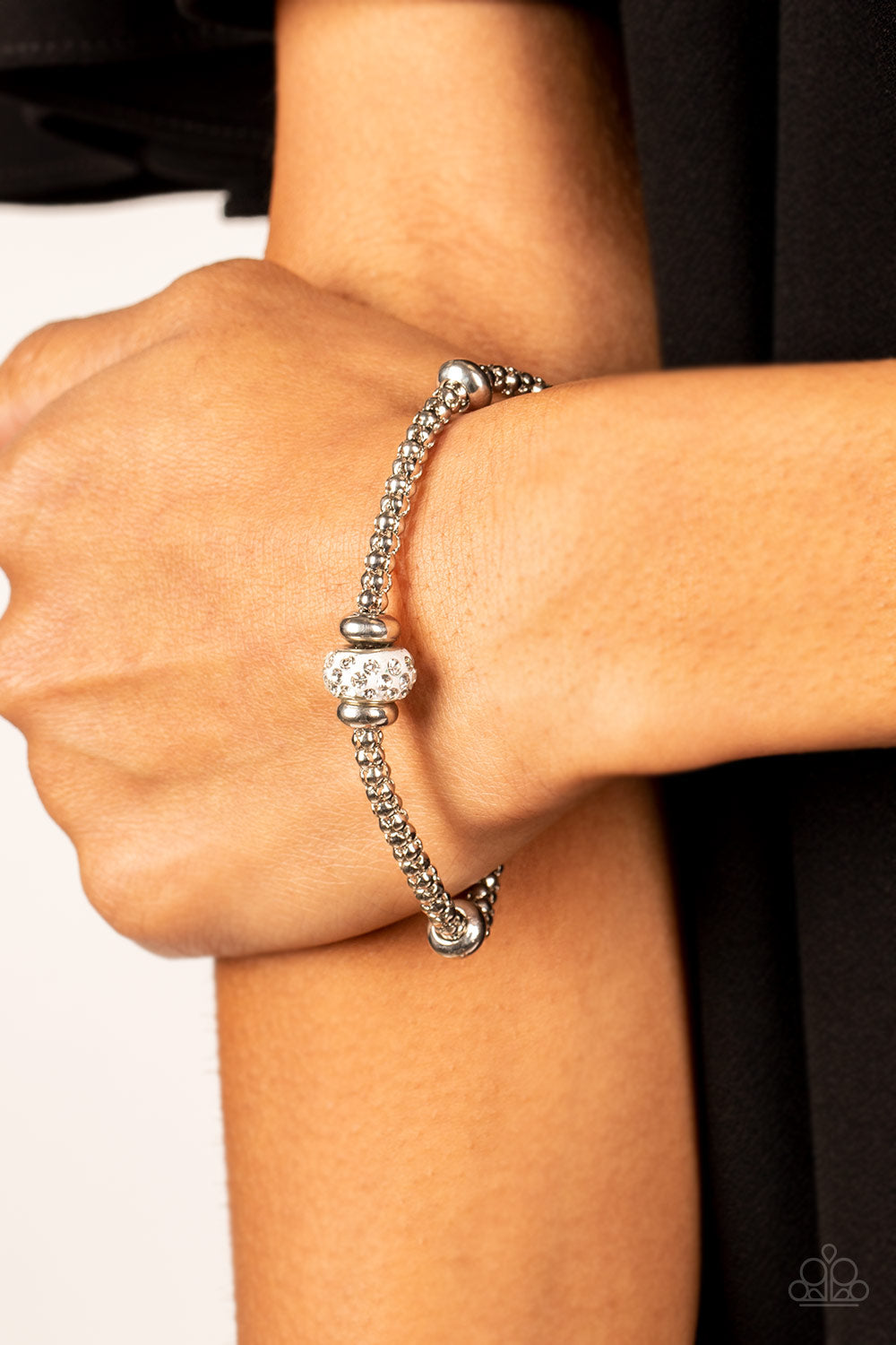Paparazzi Accessories Downtown Decoupage - White Flanked by silver disc-like beads, a white rhinestone dotted bead adorns the center of a silver popcorn chain around the wrist for a dazzling finish. Features an adjustable clasp closure. Sold as one indivi