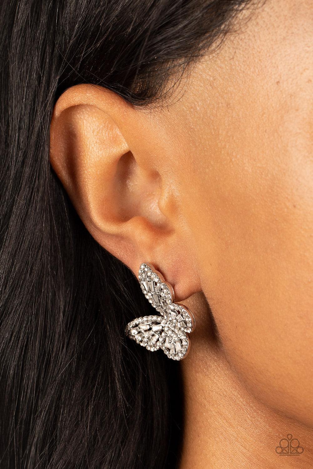 Paparazzi Accessories Smooth Like FLUTTER - White Bordered in dainty white rhinestones, emerald cut white rhinestones sparkle inside the silver wings of a butterfly for an enchanting fashion. Earring attaches to a standard post fitting. Sold as one pair o