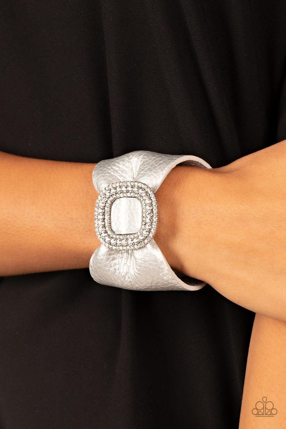 Paparazzi Accessories Lights, SELFIE, Action! - Silver Brushed in a shimmery silver finish, a thick pleather band delicately knots around the wrist. Stacked with brilliant white rhinestones, a dramatic silver buckle sparkles at the center of the wrist for